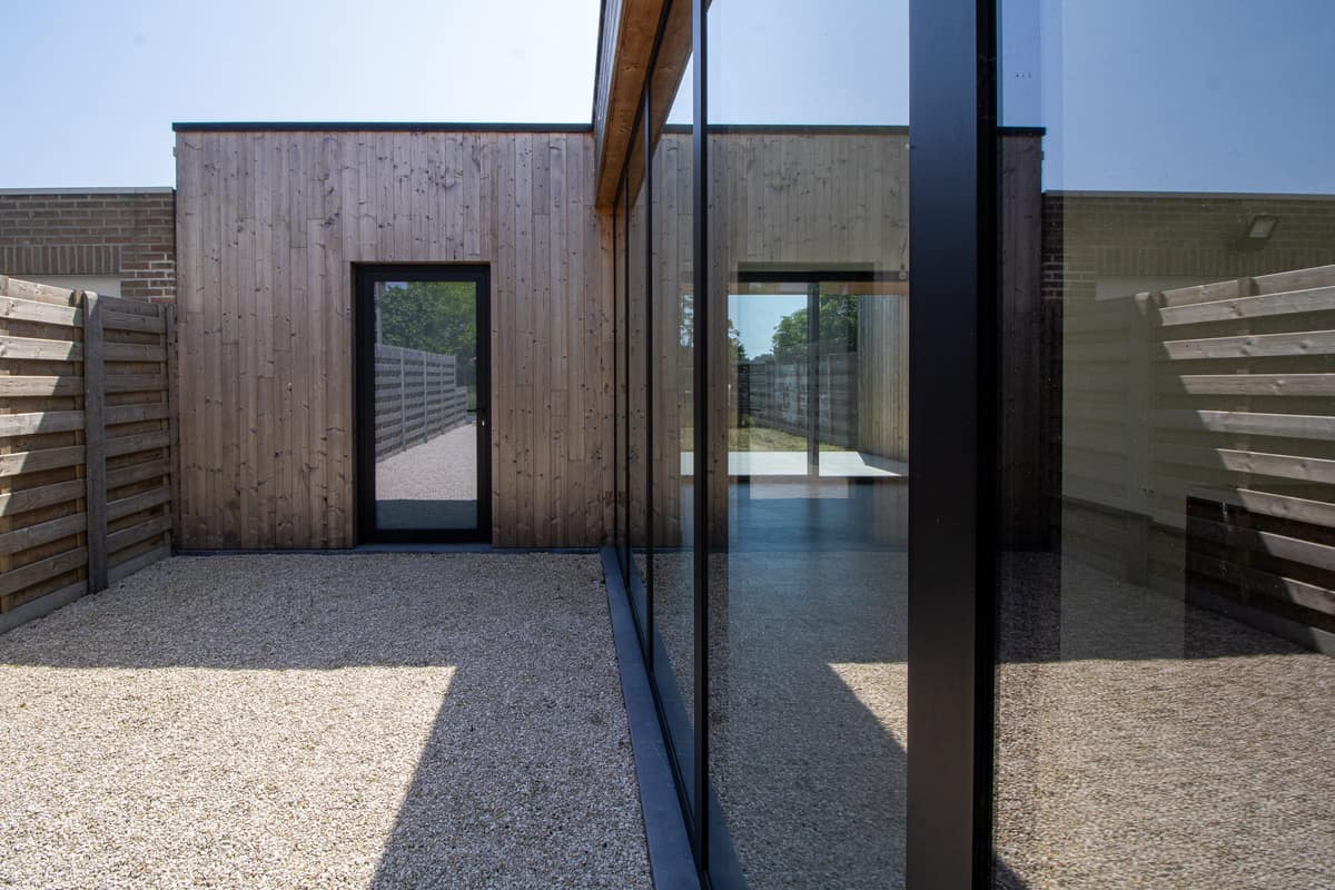 Binnenkoer met houten bijgebouw en glazen gevel
