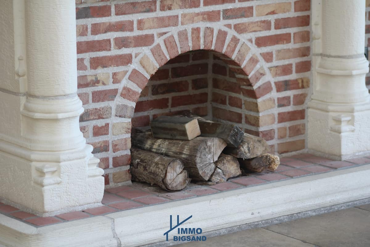 Open haard met brandhout in een bakstenen nis