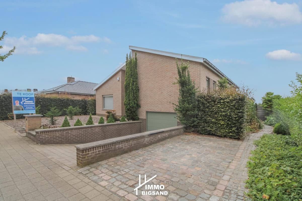 Voorkant van een woning met oprit en aangelegde tuin
