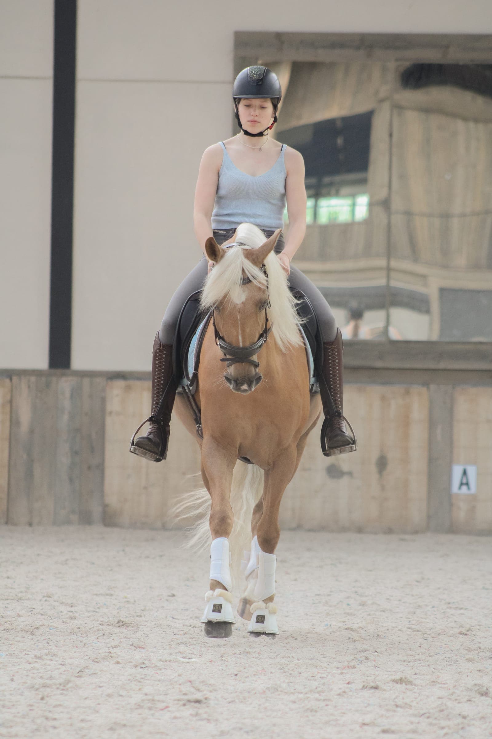 Amazone te paard, recht naar de camera toe in de binnenpiste